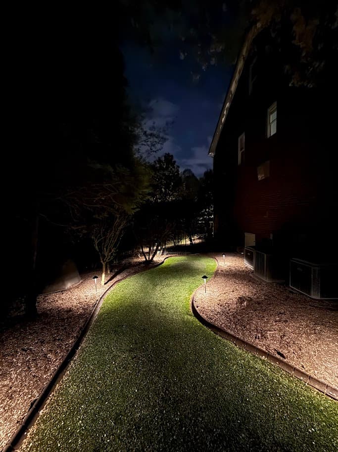 Side yard corridor lit by path lights