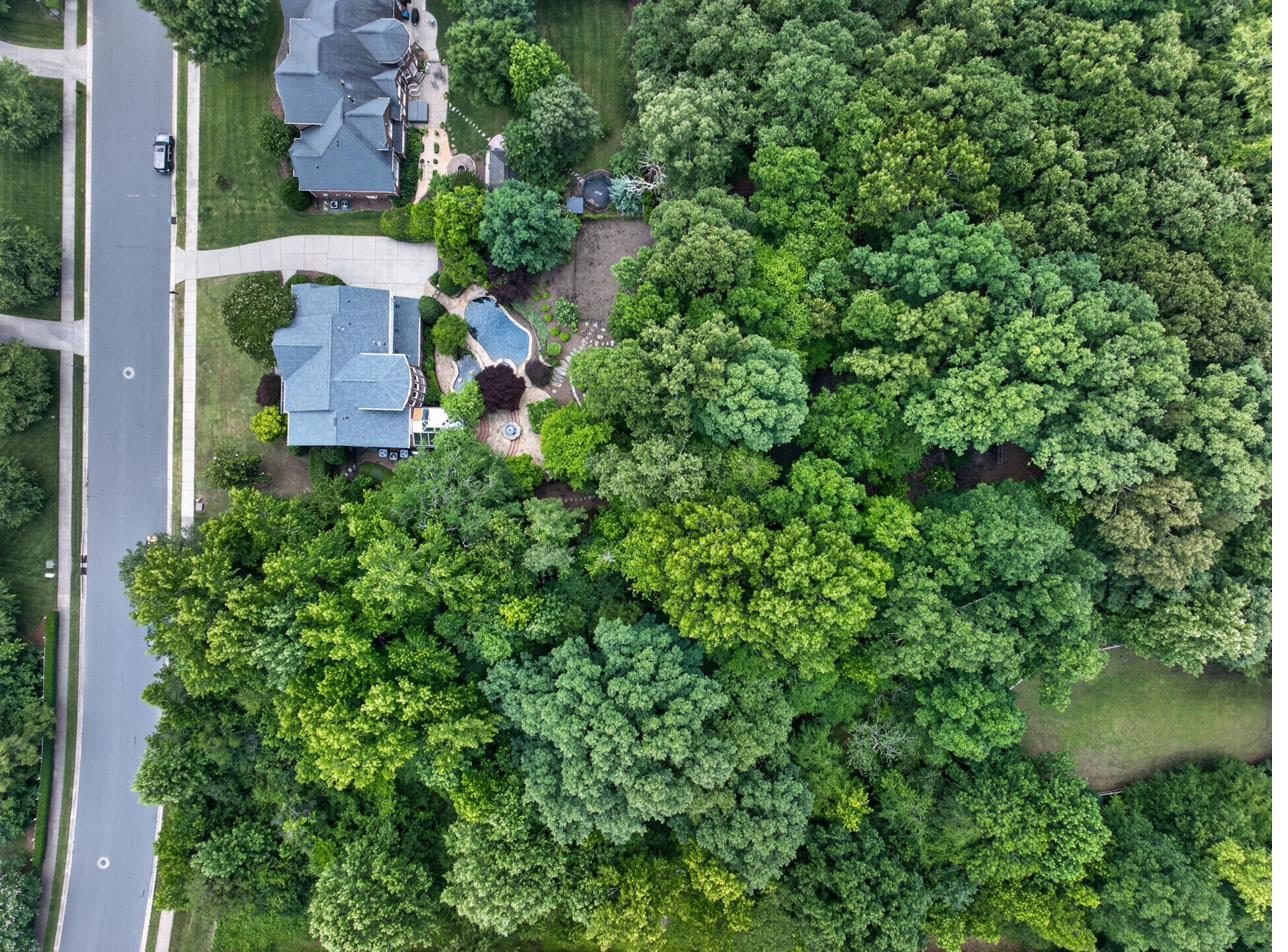 Aerial view of the rear parcel showing creek, bridge, and heritage cabin